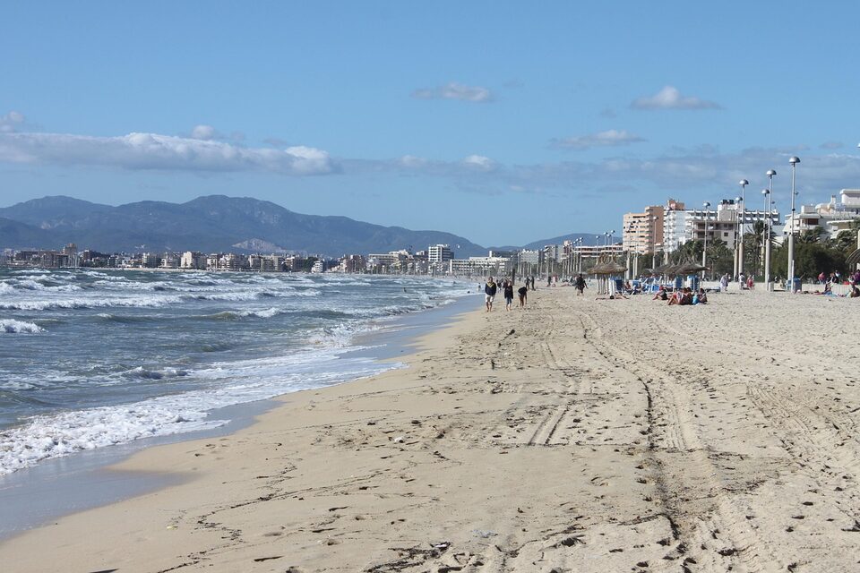 Breiter Sandstrand auf Mallorca mit Blick auf die Küste