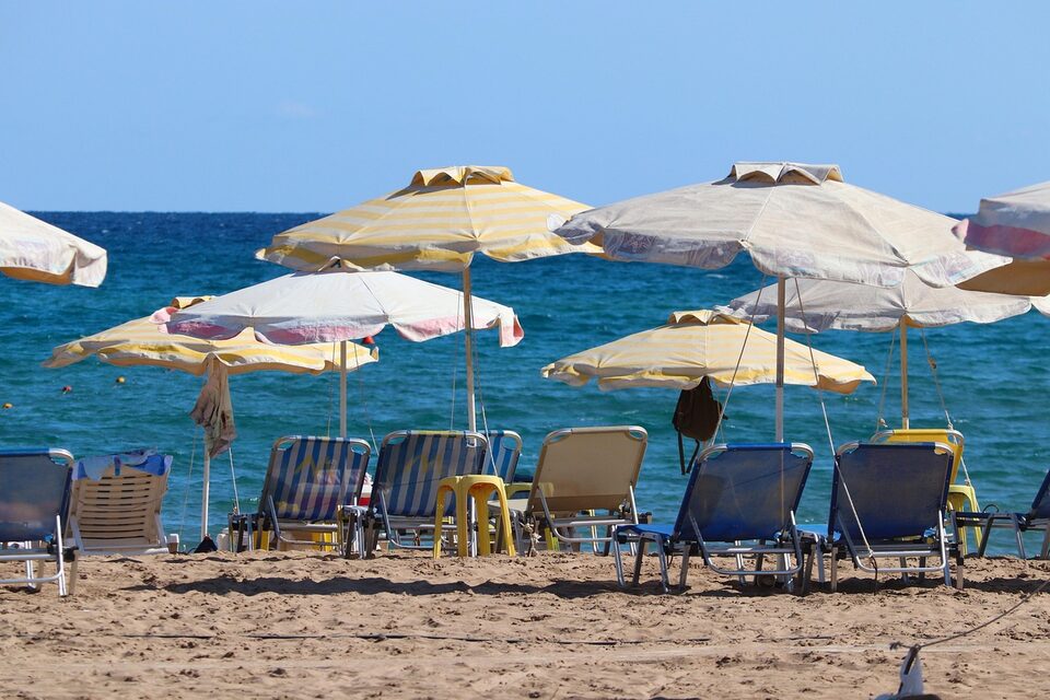 Strand mit Sonnenschirmen und Liegen auf Rhodos